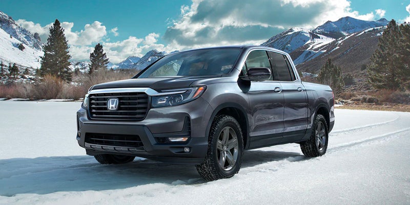 Front right view of a 2023 Honda Ridgeline parked in the snow