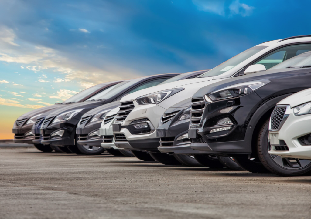 A photo of several cars lined up at a car dealership.