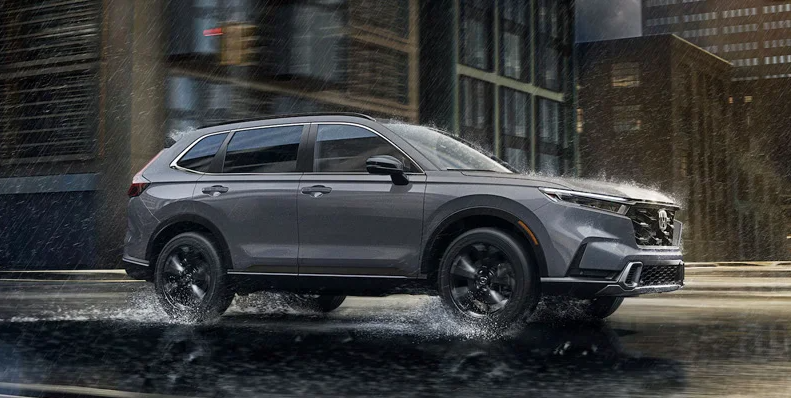 A photo of a 2025 Honda CR-V driving down a road in the rain.