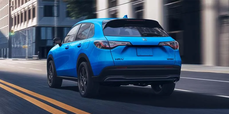 A photo of a 2025 Honda HR-V driving down a city road.