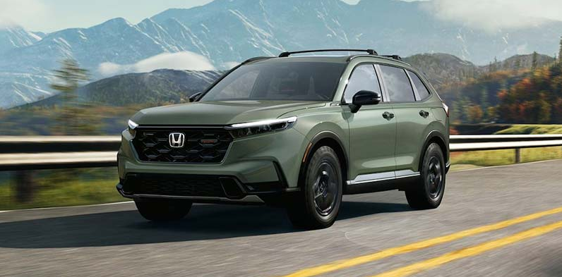 A green 2026 Honda CR-V driving down the road.