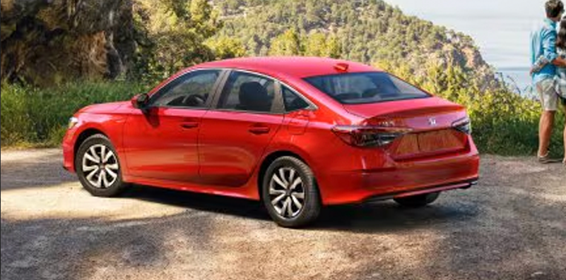 A red 2026 Honda Civic Sedan parked on a dirt road.