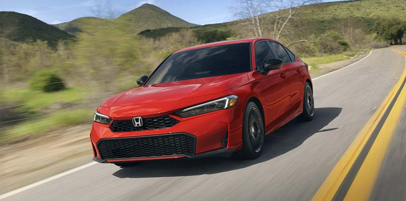A red 2025 Honda Civic Hybrid driving down the road.