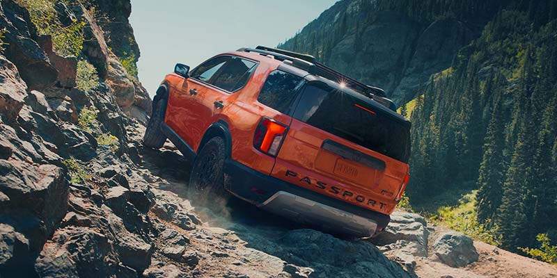 New 2026 Honda Passport in it's back profile in climbing mountains