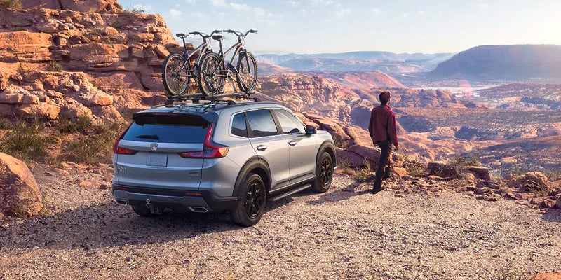 Rear view of a 2023 Honda CR-V Hybrid parked at the edge on a canyon