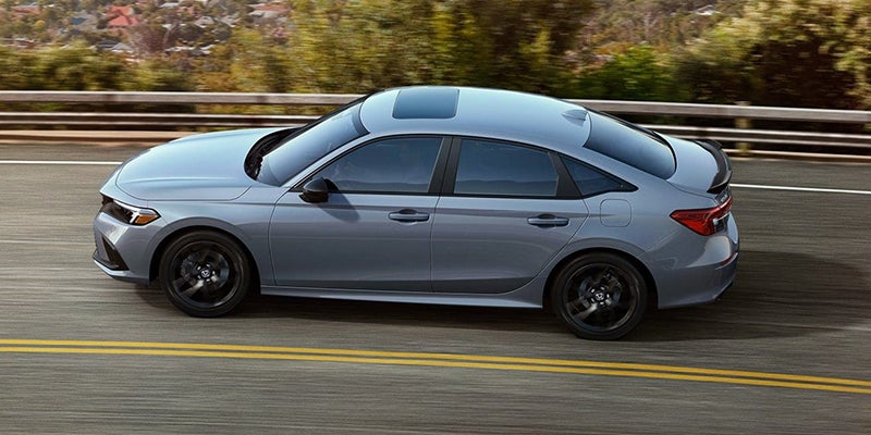 A grey 2024 Honda Civic Si drives on a highway